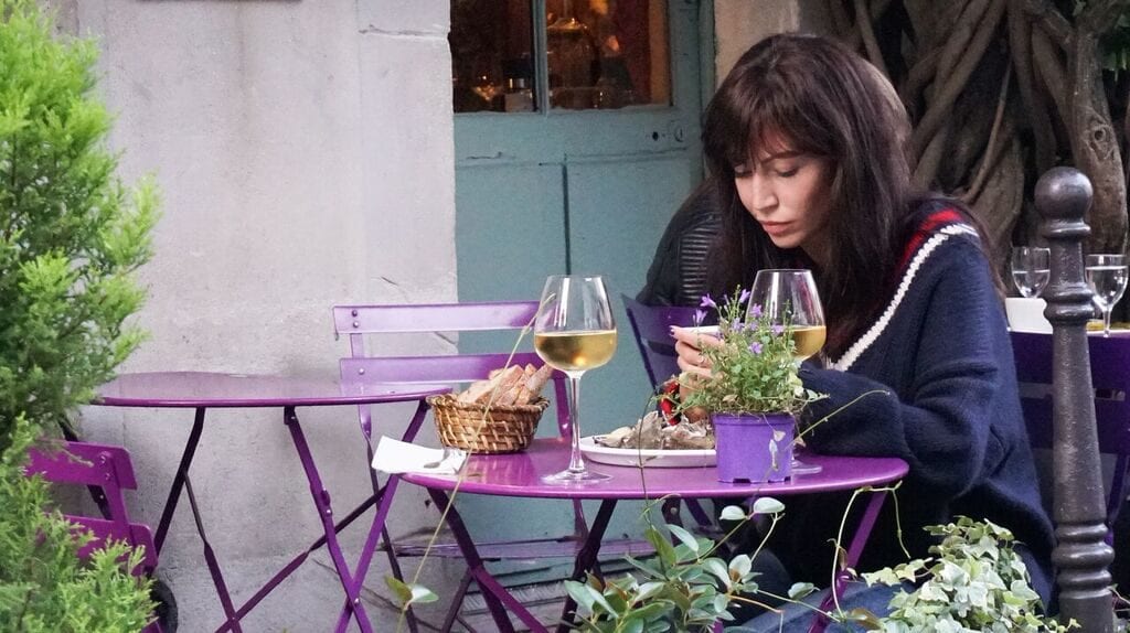 Girl At Purple Table Reading Book Having Wine At Best Restaurants In Paris Au Vieux Paris Restaurant